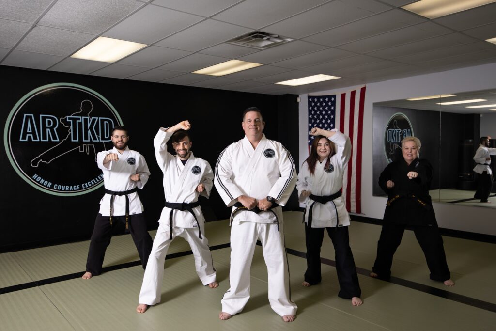 Stiles family posing in traditional Taekwondo stances at AR TKD, showcasing their leadership and dedication to their family-owned Taekwondo school.