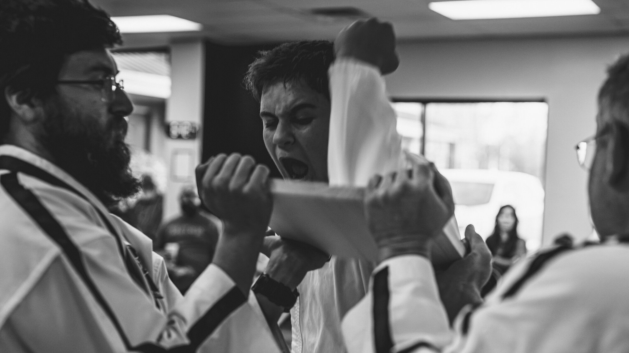 AR TKD instructor holding a board for a student to break